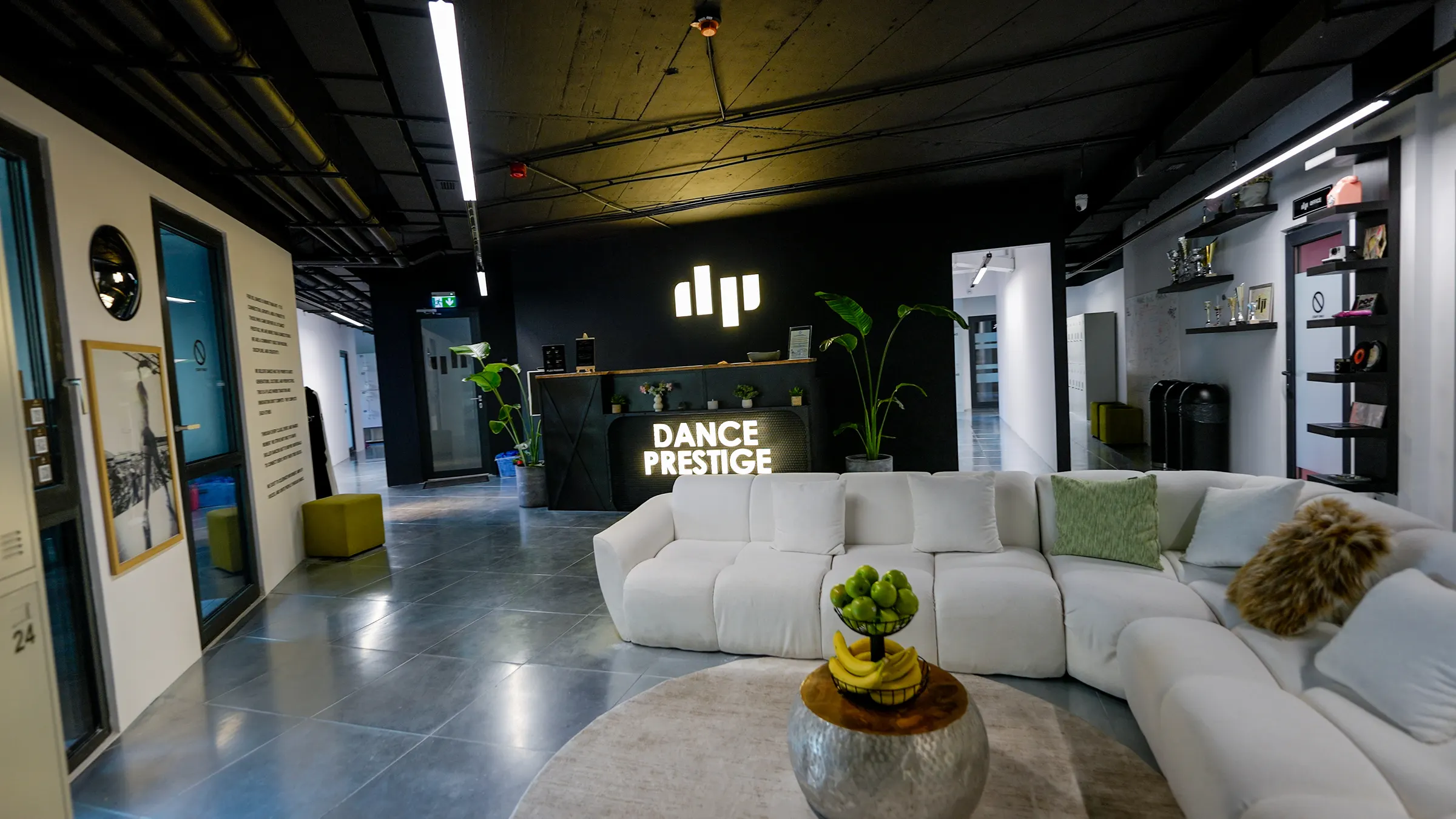 The Dance Prestige reception: white sofa, plants and the lit-up logo